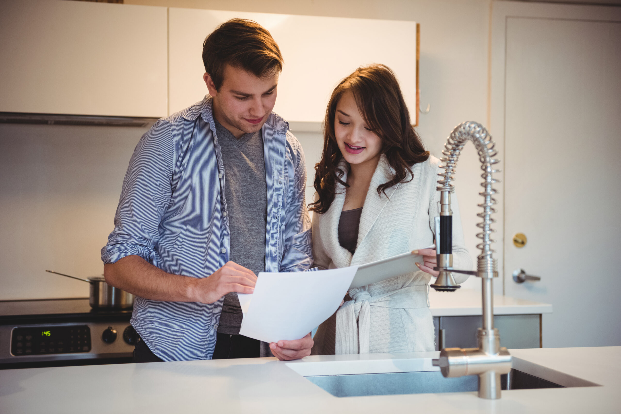 couple discussing digital tablet kitchen scaled